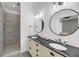 Bathroom boasts double vanity with granite counters, round mirrors, and tiled walk-in shower at 119 White Picket Ln, Summerville, SC 29483