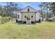 Back exterior view of a white cottage-style home with a porch and landscaped yard at 119 White Picket Ln, Summerville, SC 29483
