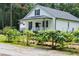 Charming white cottage featuring a cozy front porch and a lovely garden in the front yard at 119 White Picket Ln, Summerville, SC 29483