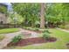 Outdoor patio with a built-in fire pit surrounded by lush landscaping at 1200 Out Of Bounds Dr, Summerville, SC 29485