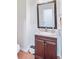 Compact powder room featuring a granite vanity top, dark wood cabinets, and a large framed mirror at 1200 Out Of Bounds Dr, Summerville, SC 29485