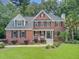 Traditional brick home with a manicured lawn, mature trees, and classic architectural details at 1200 Out Of Bounds Dr, Summerville, SC 29485