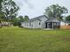 The home features a screened in porch, with vinyl siding, and a large backyard lawn at 1207 Albert Storm Ave, Moncks Corner, SC 29461