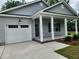 New home with garage and front porch and manicured lawn at 1207 Albert Storm Ave, Moncks Corner, SC 29461