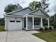 New home with garage and front porch and manicured lawn at 1207 Albert Storm Ave, Moncks Corner, SC 29461