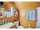 Cozy bathroom featuring knotty pine walls, vanity and tiled countertop and framed mirror at 125 Drayton Dr, Summerville, SC 29483