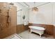 Luxurious bathroom featuring glass shower and separate bathtub, decorative wall trim and unique light fixture at 125 Drayton Dr, Summerville, SC 29483