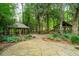 Beautifully landscaped garden featuring two wooden gazebos, connected by a stone pathway, nestled among lush greenery at 125 Drayton Dr, Summerville, SC 29483