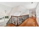 Bright hallway with gleaming hardwood floors and wrought iron banister overlooking the lower level at 125 Drayton Dr, Summerville, SC 29483