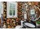 Chic powder room showcases floral wallpaper, a round mirror, and a black vanity at 125 Drayton Dr, Summerville, SC 29483
