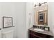 Stylish powder room featuring a granite vanity and decorative mirror at 125 Drayton Dr, Summerville, SC 29483
