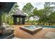 Outdoor space with a hot tub and pergola overlooking lush landscaping and a lake at 127 Blue Heron Pond Rd # C, Kiawah Island, SC 29455