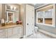 A neutral-toned bathroom with granite countertops, modern fixtures and natural light from a window at 127 Blue Heron Pond Rd # C, Kiawah Island, SC 29455