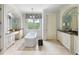 Inviting bathroom with a freestanding tub, custom cabinets, and natural light from a large window at 127 Blue Heron Pond Rd # C, Kiawah Island, SC 29455