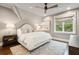 Bright, airy bedroom with a ceiling fan, patterned rug, and view of mature trees through a window at 127 Blue Heron Pond Rd # C, Kiawah Island, SC 29455