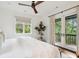Bedroom featuring large windows, a ceiling fan, and balcony access with views of trees at 127 Blue Heron Pond Rd # C, Kiawah Island, SC 29455