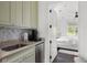 Convenient kitchenette with stainless steel sink, beverage cooler, and modern appliances near the bedroom at 127 Blue Heron Pond Rd # C, Kiawah Island, SC 29455