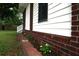 Charming exterior showcasing a brick foundation, white siding, and a neatly planted flower bed, adding curb appeal at 127 Roberts Rd, Summerville, SC 29483