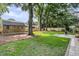 Large, grassy backyard features a wooden shed, mature trees, and a wooden fence for privacy at 1391 Fairfield Ave, Charleston, SC 29407
