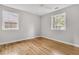 Minimalist bedroom with hardwood floors, two windows and a soothing color scheme at 1391 Fairfield Ave, Charleston, SC 29407