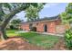 Brick home exterior showcasing a well-kept lawn, patio, mature trees, and tidy landscaping at 1391 Fairfield Ave, Charleston, SC 29407