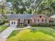 Beautiful brick home with a lush lawn, decorative landscaping, and a cozy front porch at 1391 Fairfield Ave, Charleston, SC 29407