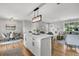 Open concept kitchen with island and seating, flowing into dining and living areas at 1391 Fairfield Ave, Charleston, SC 29407