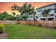 Spacious backyard featuring a well manicured lawn, wood fencing, and a two-story home under a beautiful sunset at 1494 N Lakeshore Dr, Mount Pleasant, SC 29466