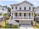 A charming two-story white home with a welcoming porch adorned with flags and palm trees in the yard at 1494 N Lakeshore Dr, Mount Pleasant, SC 29466