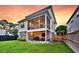 Rear exterior of a two-story home showcases a covered patio, wood fencing and lush green grass under a beautiful sunset at 1494 N Lakeshore Dr, Mount Pleasant, SC 29466