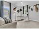 A well-lit home office with carpet features neutral walls, a modern desk and gray couch with gray curtains on the windows at 1494 N Lakeshore Dr, Mount Pleasant, SC 29466