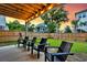 Covered outdoor patio featuring a wood ceiling, multiple black chairs, wood fencing and lush green grass at 1494 N Lakeshore Dr, Mount Pleasant, SC 29466