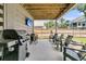 Outdoor patio with a wood ceiling features a built-in TV, multiple black chairs, a grill and wood fencing at 1494 N Lakeshore Dr, Mount Pleasant, SC 29466