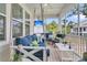 Relaxing outdoor screened porch features a porch swing, ceiling fan, and outdoor furniture with a TV in the background at 1494 N Lakeshore Dr, Mount Pleasant, SC 29466