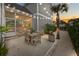 Charming backyard patio with dining set, palm tree, string lights, and screened porch for outdoor enjoyment at 1557 Kepley Dr, Mount Pleasant, SC 29464