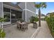 Charming backyard patio with dining set, palm tree, string lights, and screened porch for outdoor enjoyment at 1557 Kepley Dr, Mount Pleasant, SC 29464
