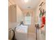 Functional laundry room with washer, dryer, storage cabinets, and organized cleaning supplies at 157 Village Ponds Dr, Summerville, SC 29483