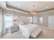 This spacious Primary bedroom is complete with an elegant chandelier and bench seating at 157 Village Ponds Dr, Summerville, SC 29483