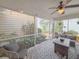 Cozy screened patio with comfortable seating, string lights, ceiling fan, and views of lush garden at 157 Village Ponds Dr, Summerville, SC 29483