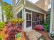 Charming entrance to screened patio adorned with colorful flowers and lush greenery at 157 Village Ponds Dr, Summerville, SC 29483