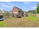 Fenced backyard featuring a detached garage, outdoor dining set, and a custom playhouse at 1576 Nautical Chart Dr, Charleston, SC 29414