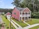 Charming red two-story home with a double porch, well-manicured lawn, and detached garage at 1576 Nautical Chart Dr, Charleston, SC 29414