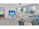 Open-concept living room boasting a cozy blue sofa, and entertainment center with a TV with beach scene at 1576 Nautical Chart Dr, Charleston, SC 29414