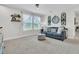 Inviting living room featuring a comfortable blue sofa, plush carpeting, and charming decorative accents and natural light at 1576 Nautical Chart Dr, Charleston, SC 29414