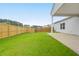 Grassy backyard featuring a wooden fence, home exterior, and covered patio at 158 Hayworth Rd, Summerville, SC 29486