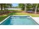 Backyard pool featuring crystal-clear water and a beautifully tiled edge, set against a green lawn and wooded backdrop at 1607 Waterside Blvd, Moncks Corner, SC 29461
