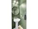 Stylish half bathroom with olive green walls, circular mirror, and pedestal sink at 1634 Eider Down Dr, Summerville, SC 29483