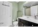 Bathroom with green walls, black cabinets, white sink and a vanity mirror at 1634 Eider Down Dr, Summerville, SC 29483