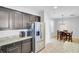 Well-lit kitchen area with stainless steel refrigerator, granite countertops, and dark cabinets at 1634 Eider Down Dr, Summerville, SC 29483