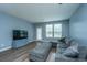 Cozy living room featuring a large sectional sofa, TV, and natural light from the windows and door at 1689 Eider Down Dr, Summerville, SC 29483